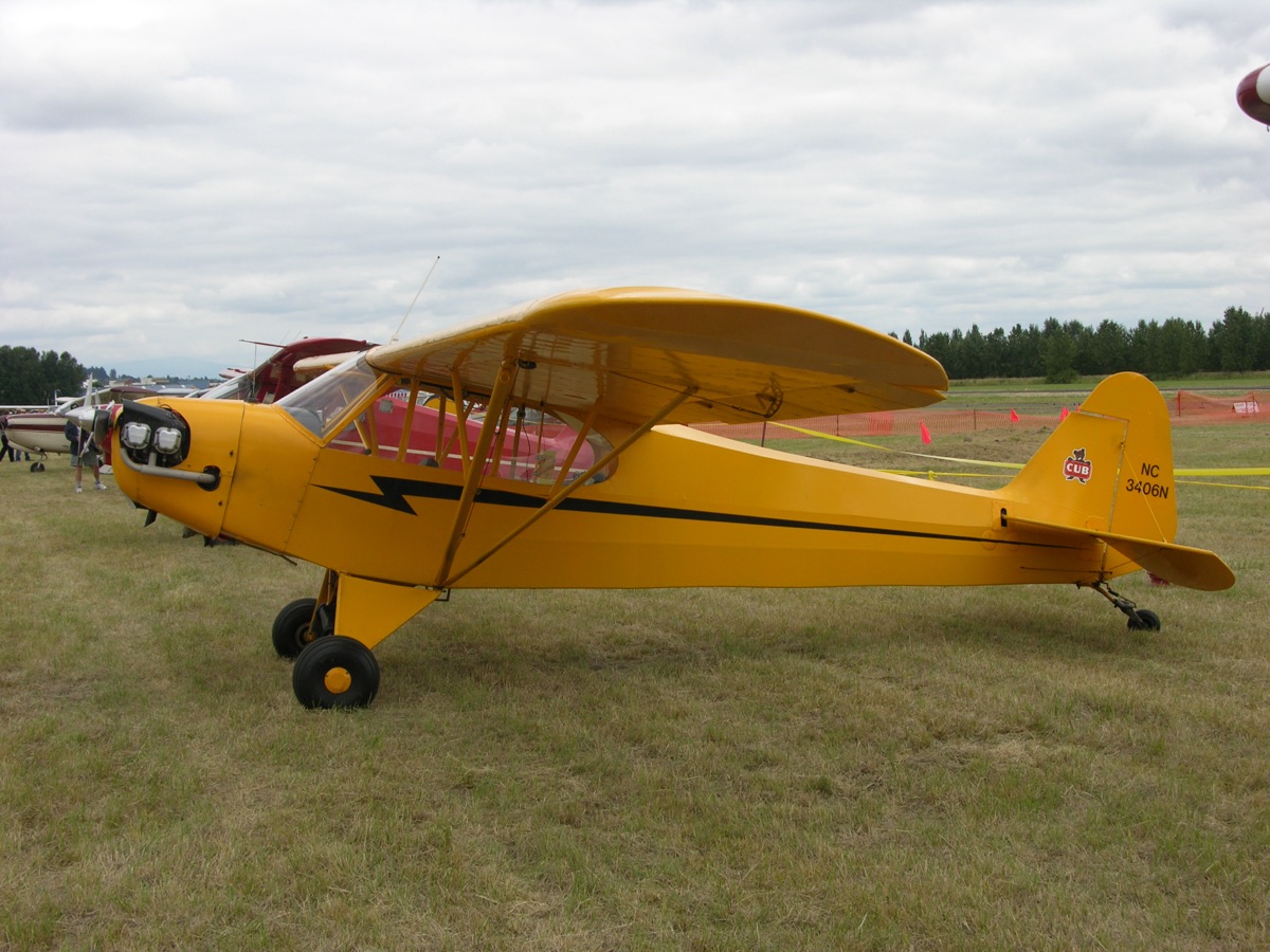 A yellow 1946 Piper J3C-65 Cub, N3406N, parked on grass